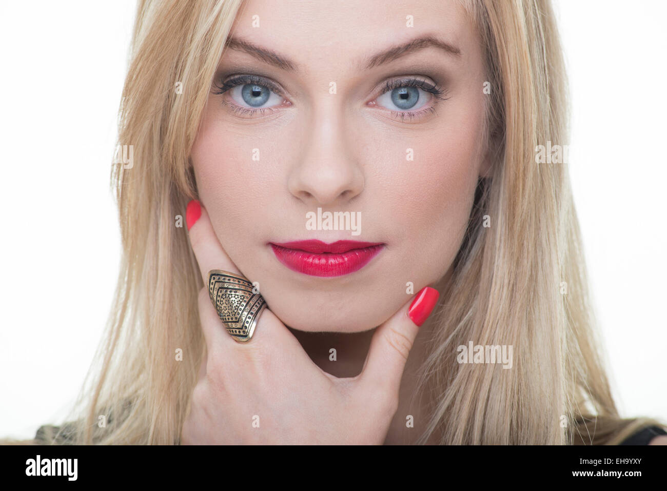 Donna bionda che indossa costituiscono la mano appoggiata sulla faccia Foto Stock