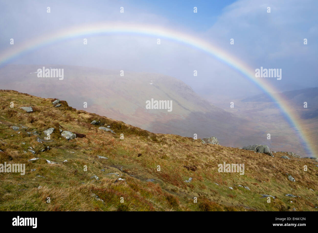 Un arcobaleno pieno con pioggia e sole sulla penna yr Helgi Du in wild Carneddau montagne del Parco Nazionale di Snowdonia (Eryri), il Galles del Nord, Regno Unito, Gran Bretagna Foto Stock