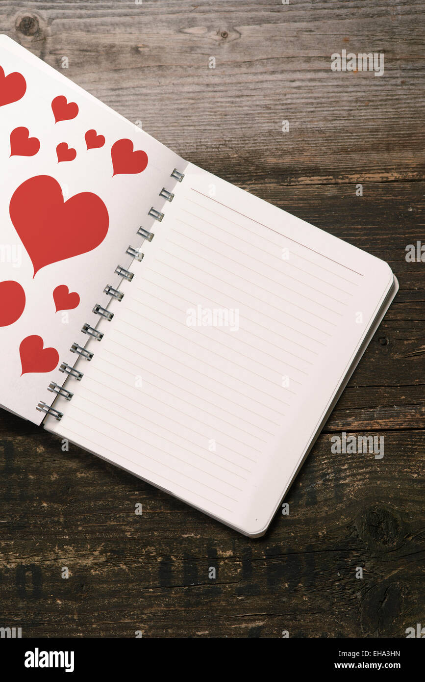 Il Blocco note di bianco al buio su un sfondo di legno Foto Stock
