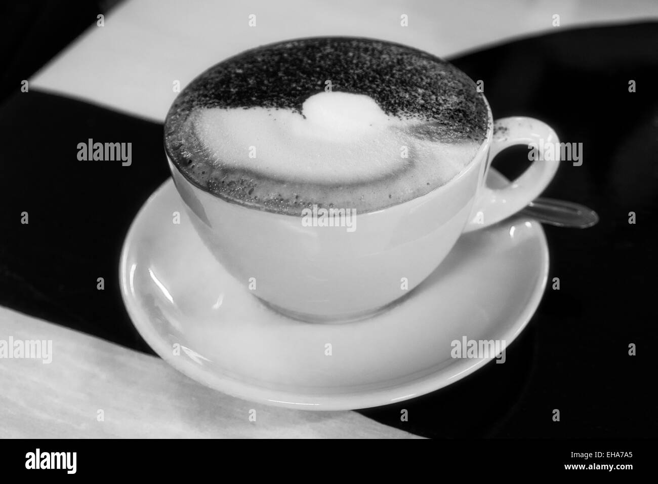 Cappuccino cremoso di cioccolato spruzzato sulla parte superiore. In bianco e nero. Foto Stock