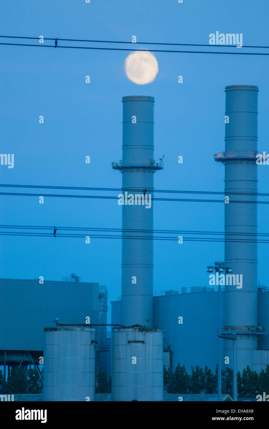 La luna scintillante nel calore di scarico dal gas Centrale elettrica alimentata a Damhead Creek, Hoo North kent Foto Stock