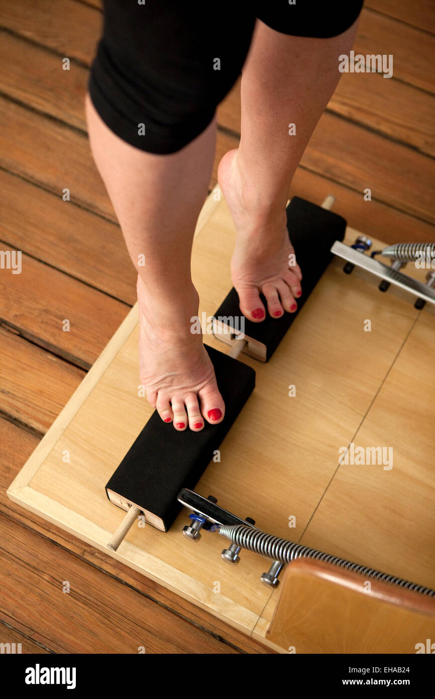 Giovane donna lo stiramento in una sala fitness Foto Stock