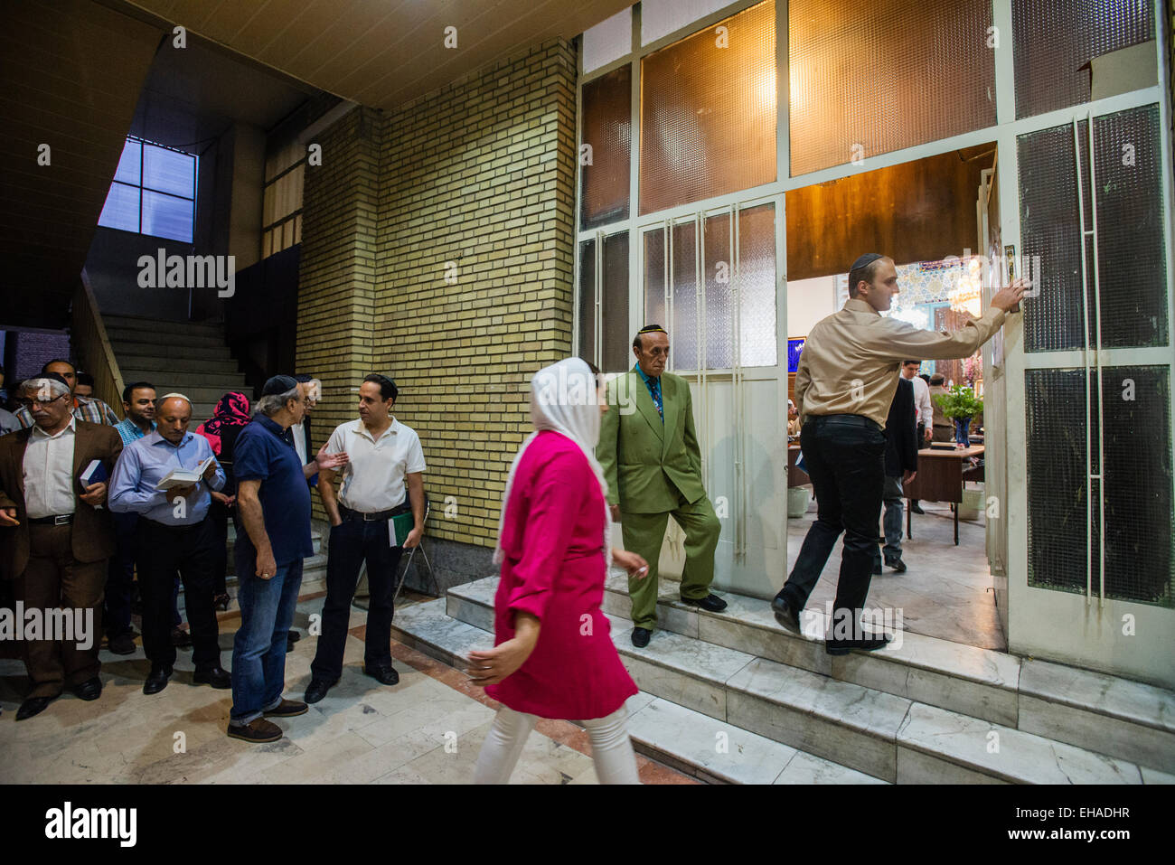 Gli ebrei entrano nella sala da preghiera e di Yusef Abad sinagoga, uno dei più grandi nel nord di Teheran e toccando mezuzà, rituale pezzo di pergamena, su Rosh Hashanah, ebraica Anno nuovo, Iran Foto Stock