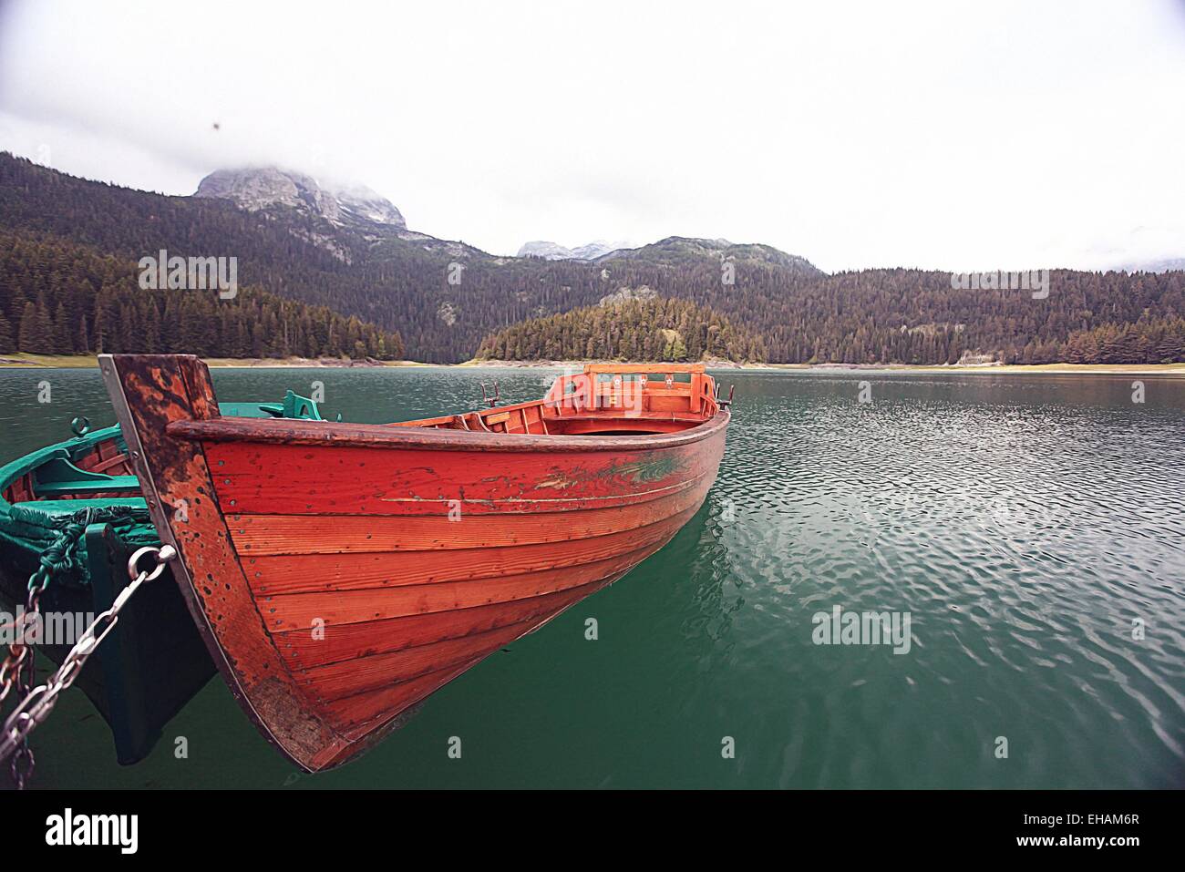 La barca di legno su un lago di montagna paesaggio cielo di montagna Foto Stock