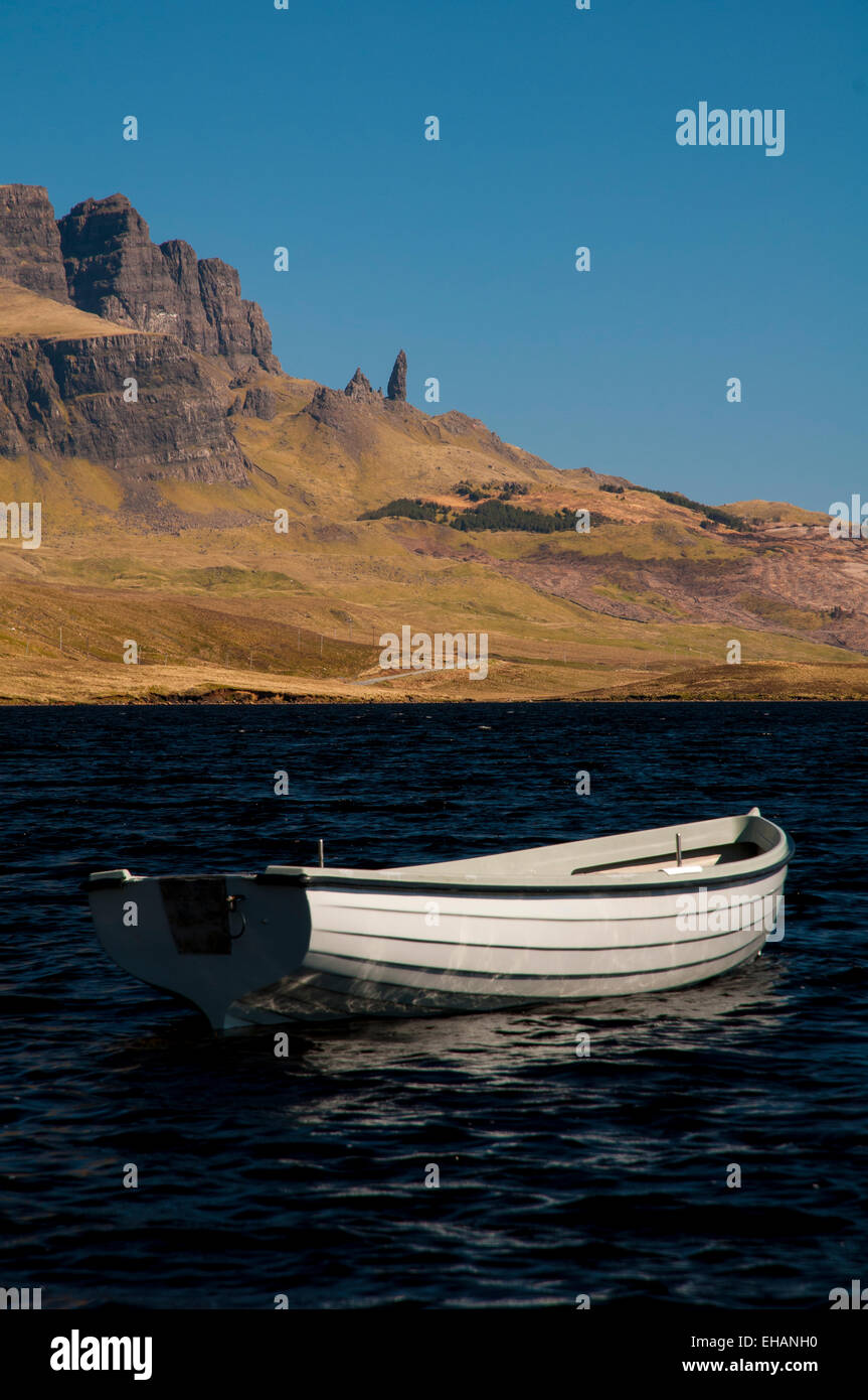 Il Storr e il vecchio uomo di Storr sotto un profondo cielo blu con un bianco di piccole barche a remi su Loch Fada in primo piano. Isola di Foto Stock