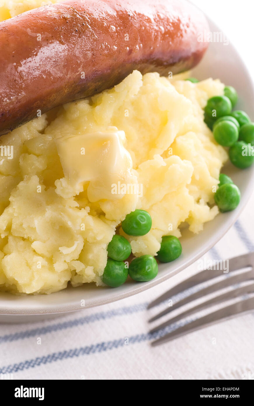 Purea di patate con burro fuso, salsiccia e piselli verdi. Foto Stock