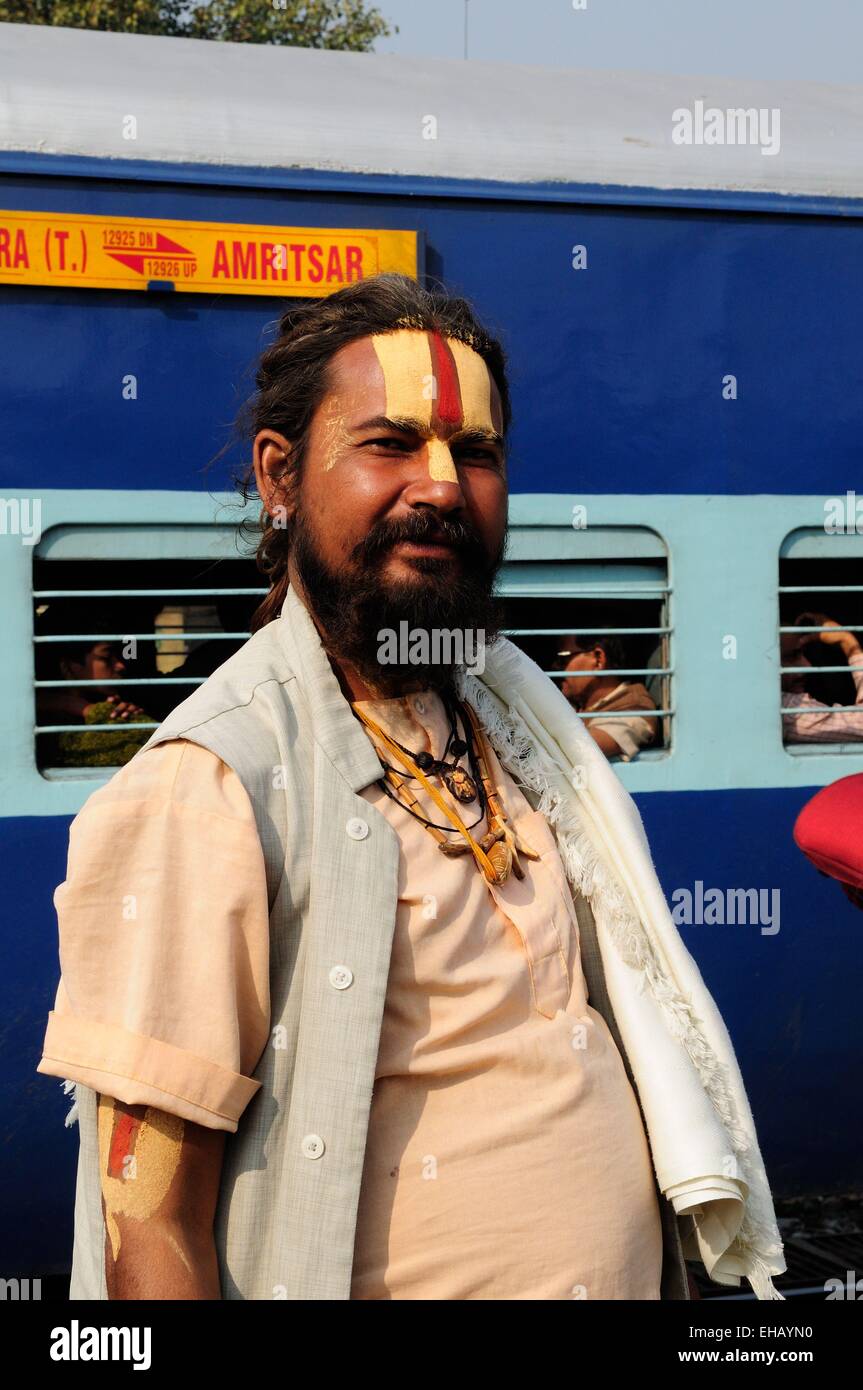 Un Vishnu devoto indiano Sadhu Uomo Santo in piedi sulla piattaforma di Delhi stazione ferroviaria con un treno in background India Foto Stock