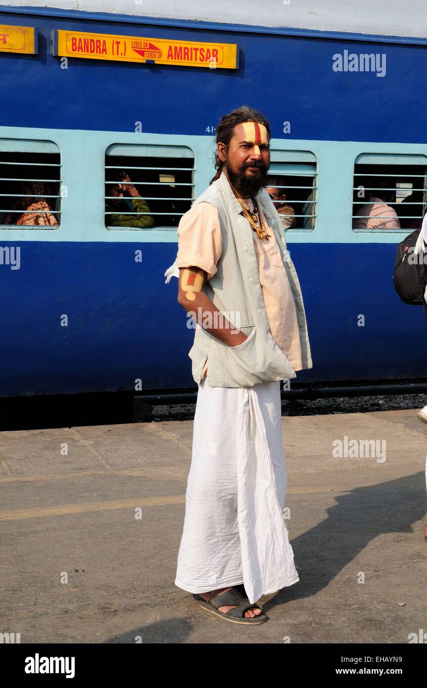 Un Vishnu devoto indiano Sadhu Uomo Santo in piedi sulla piattaforma di Delhi stazione ferroviaria con un treno in background India Foto Stock