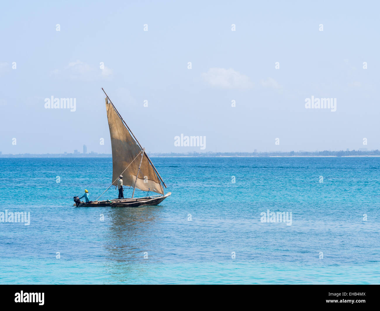 I pescatori su una barca dhow vicino a Mbudya isola in Tanzania, in una Domenica. Dar es Salaam in background. Foto Stock