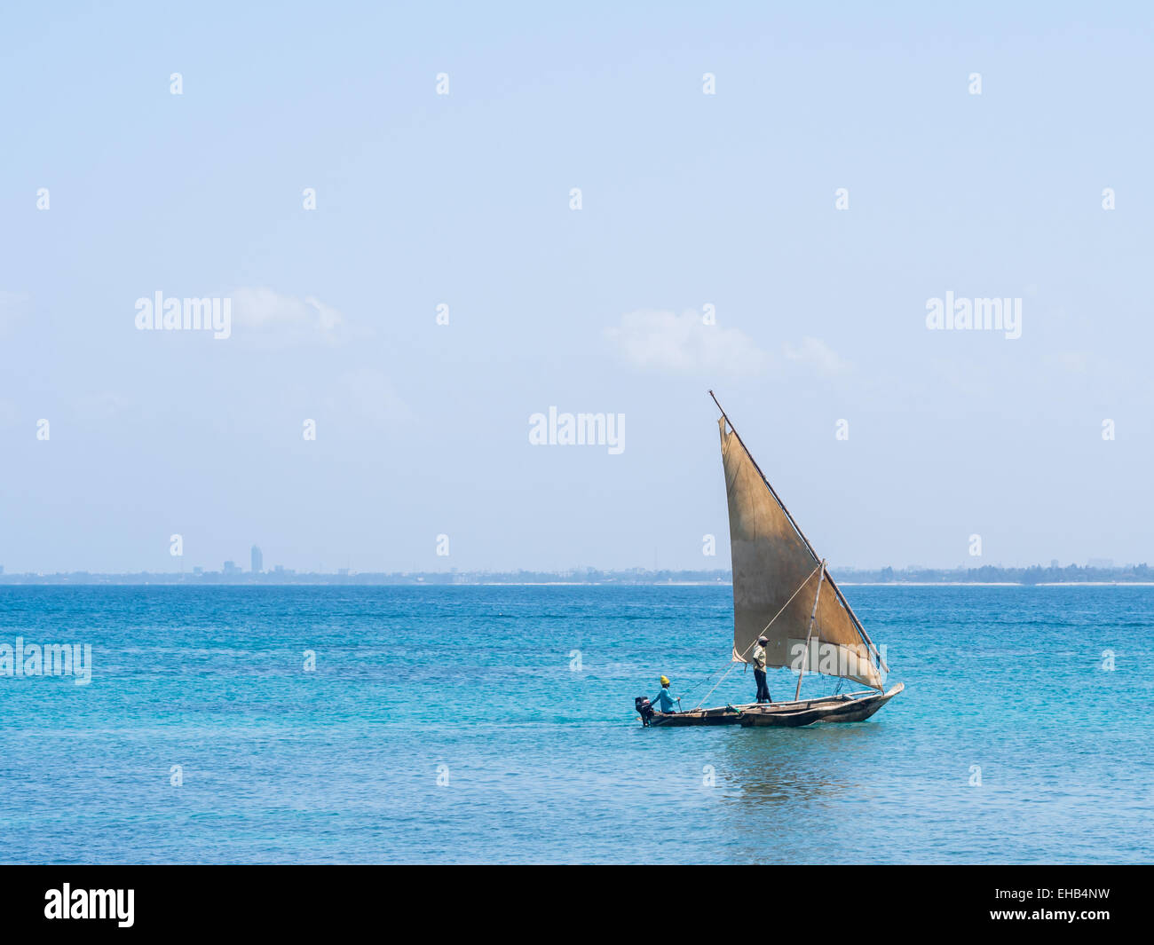 I pescatori su una barca dhow vicino a Mbudya isola in Tanzania, in una giornata di sole. Dar es Salaam in background. Foto Stock