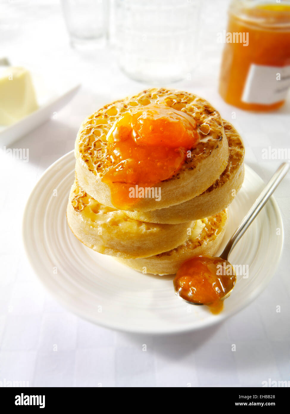Close up imburrata cialdine tostato con marmellata di albicocche pronto a mangiare in un tavolo bianco impostazione Foto Stock