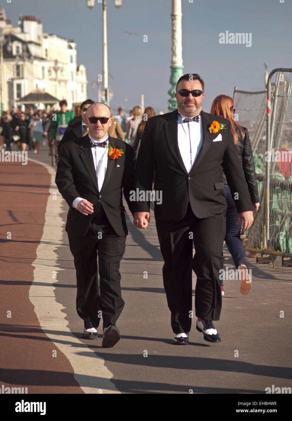 Una recente sposa coppia gay sul soleggiato lungomare in Brighton Foto Stock