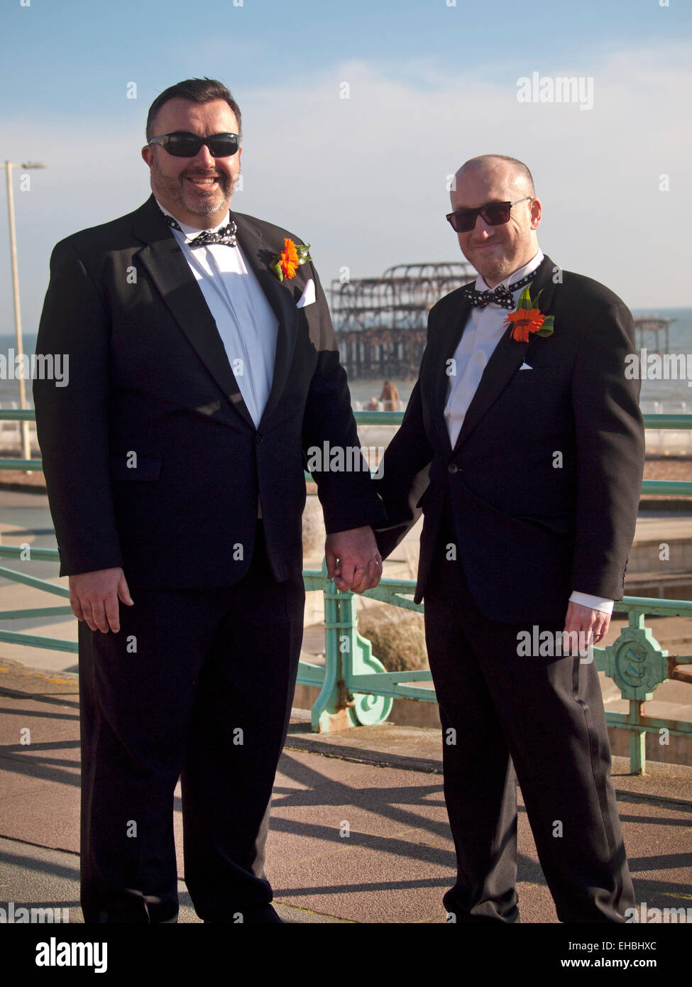 Una recente sposa coppia gay sul soleggiato lungomare in Brighton Foto Stock