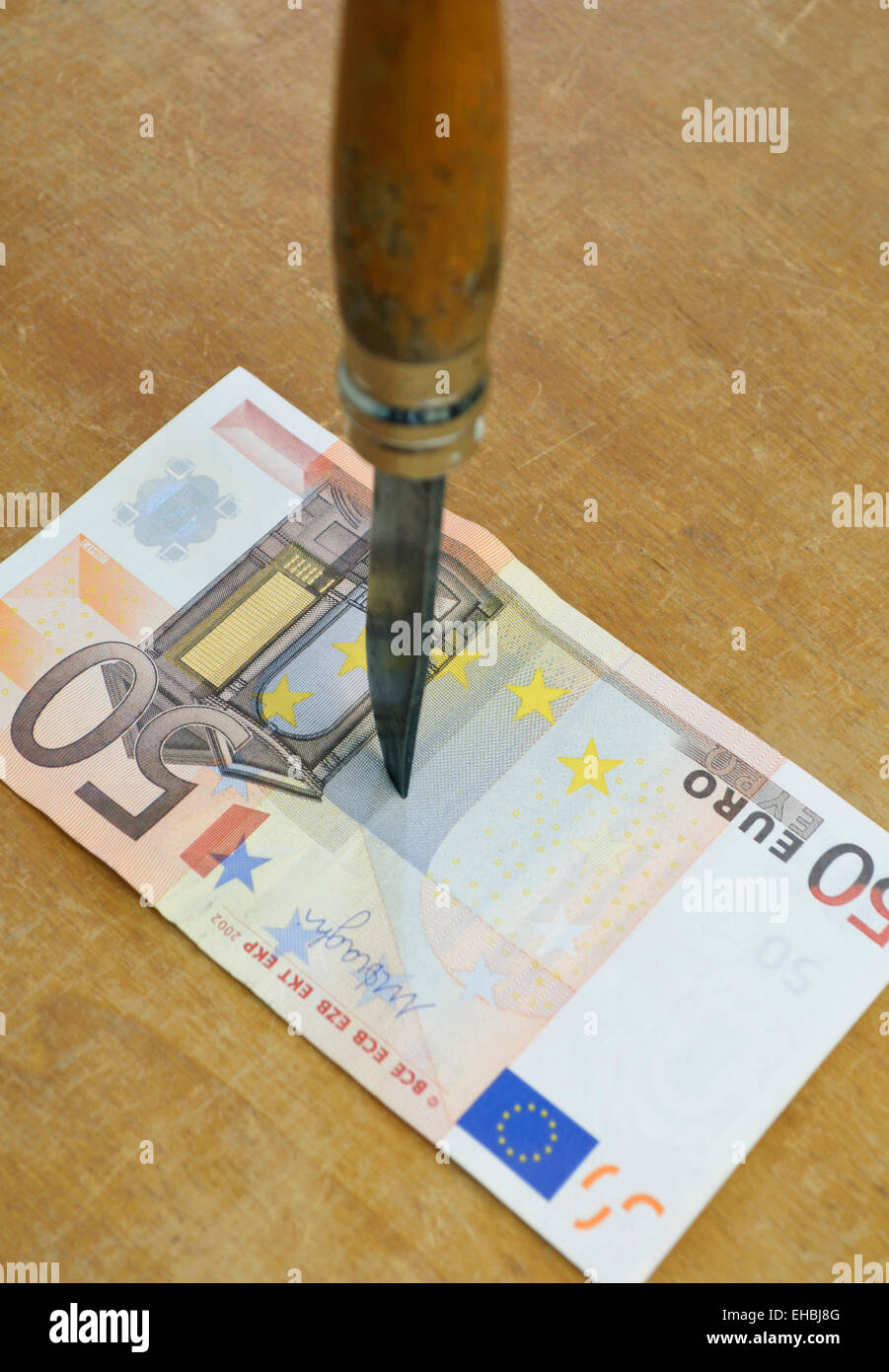 Coltello stabbing di banconote in euro Foto Stock