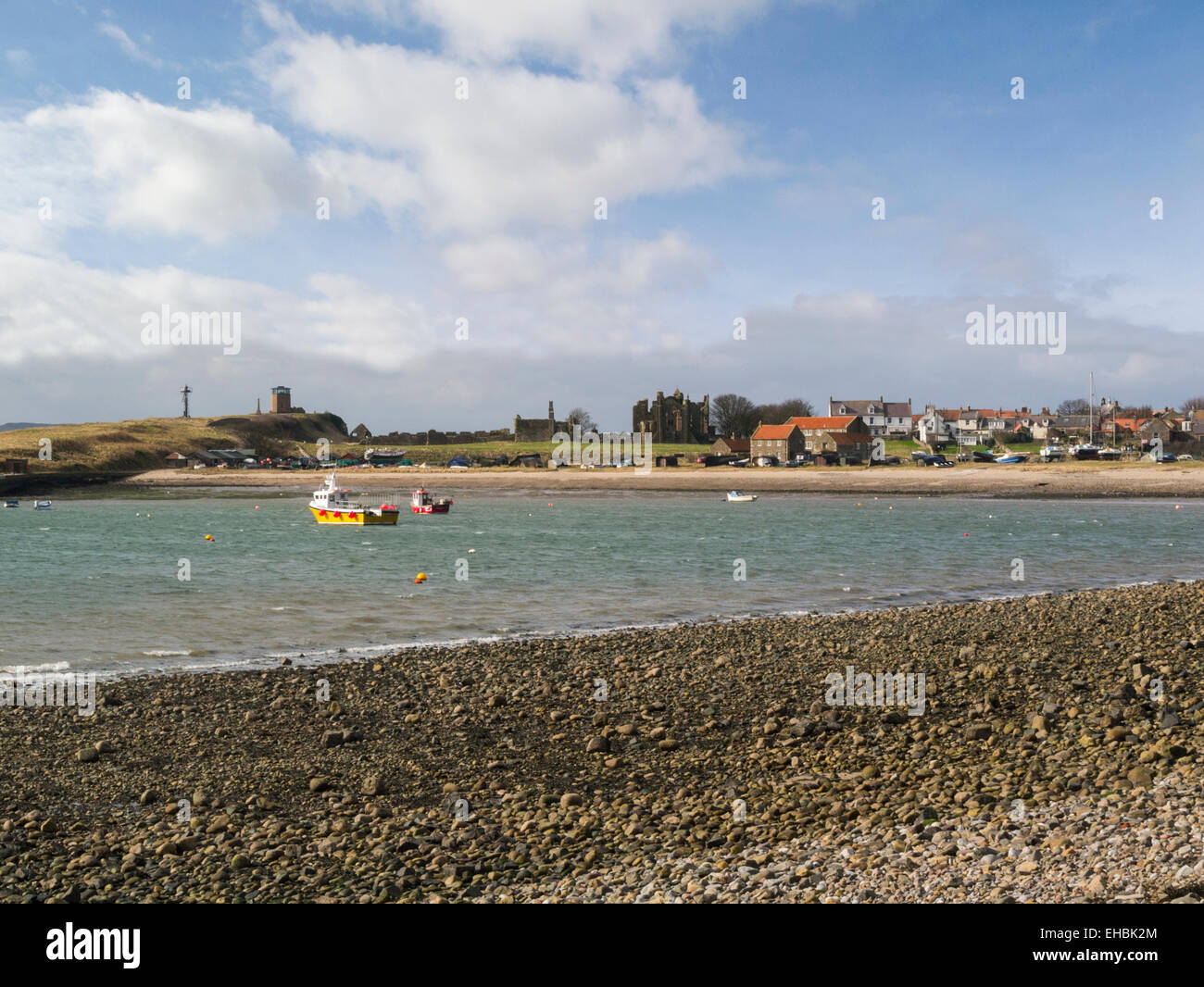 Vista sul Mare del Nord a Lindisfarne Abbazia rovine e case sull Isola Santa Northumberland England Regno Unito sulla bella giornata di marzo Foto Stock