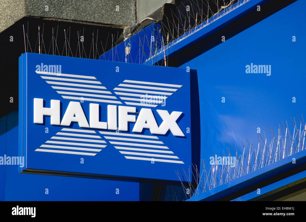 Business, finanza, banche, Halifax segno su high street bank building con metallo piccione picchi di controllo al di sopra di esso. Foto Stock