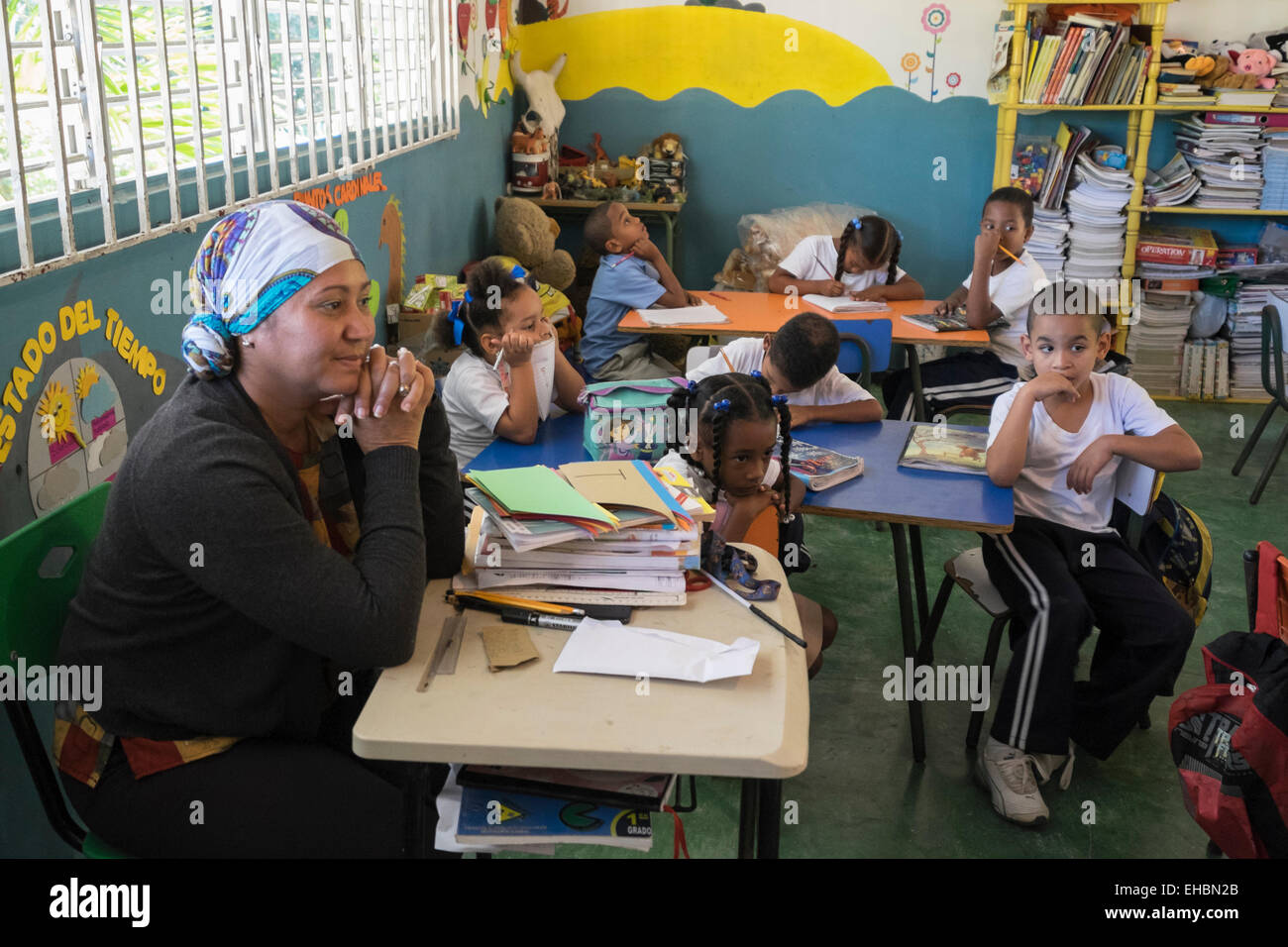 L'insegnante di scuola primaria con figli che studiano in aula di una scuola del paese vicino a Puerto Plata, Repubblica Dominicana, dei Caraibi Foto Stock