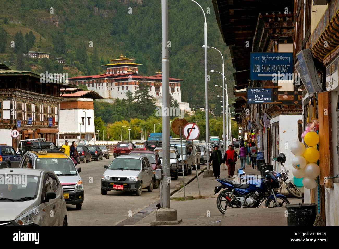 Il Bhutan - Costruito tradizionalmente shop fronti nella città di Paro. Il Paro Dzong si trova su una collina a sud della città. Foto Stock
