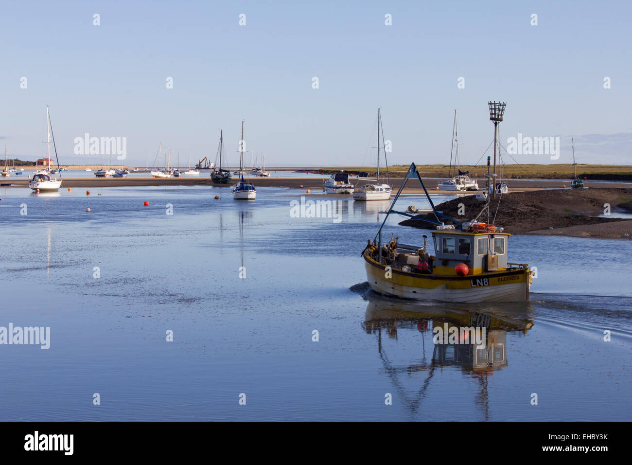 Barca da pesca di lasciare il porto a Wells accanto al mare, Norfolk, su una tranquilla e soleggiata giornata estiva. Un tipico British scena costiere. Foto Stock