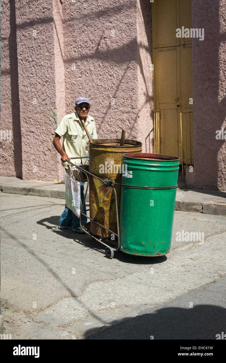 Cuba Sancti Spiritus strada vecchia scena Spazzatrice uomo cleaner due 2 bin carrello Nike berretto da baseball Foto Stock