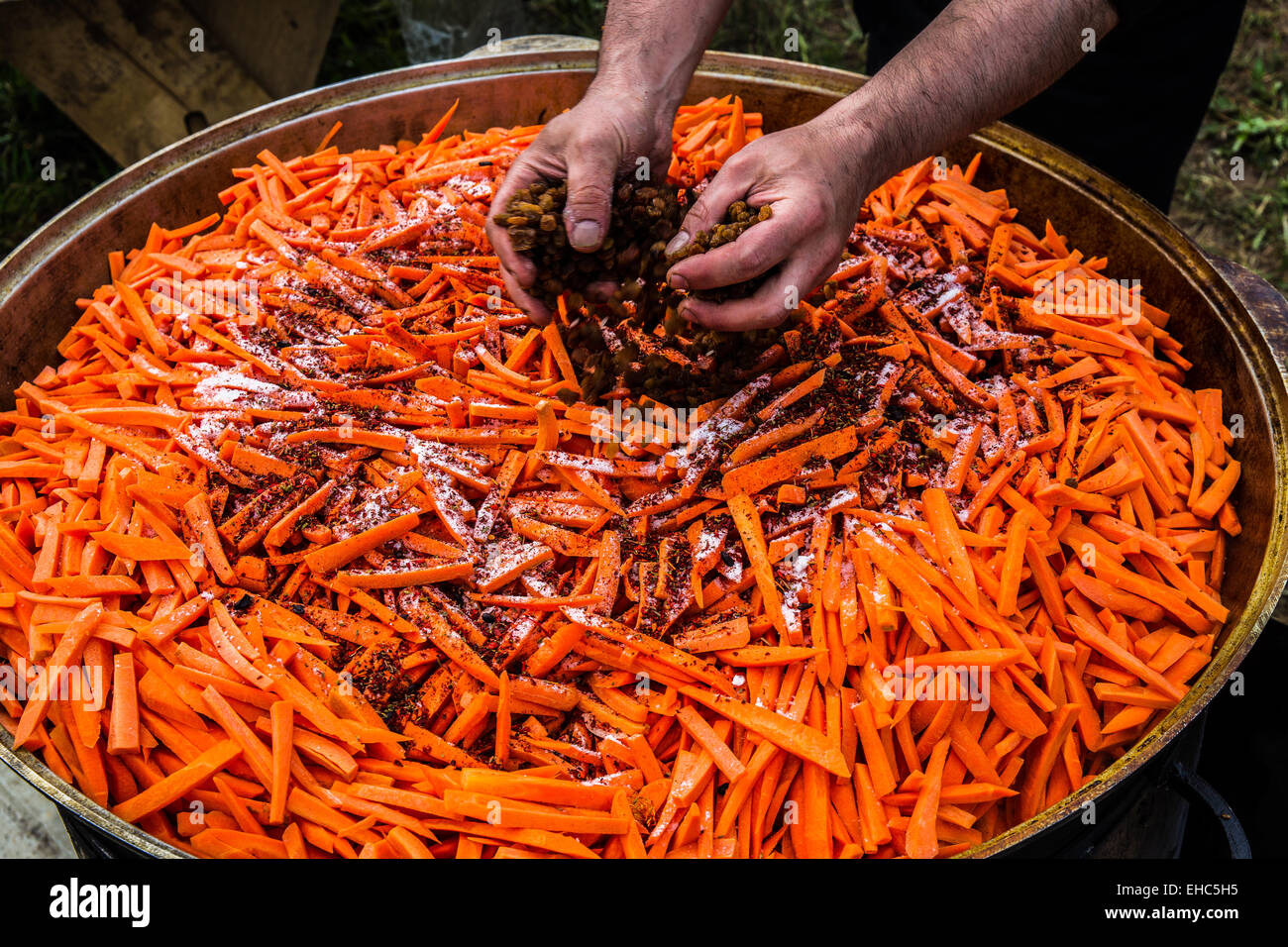 Preparazione di carni di montone pilaf - nazionale uzbeko farine di carni di montone, di riso, carote, aglio e spezie Foto Stock