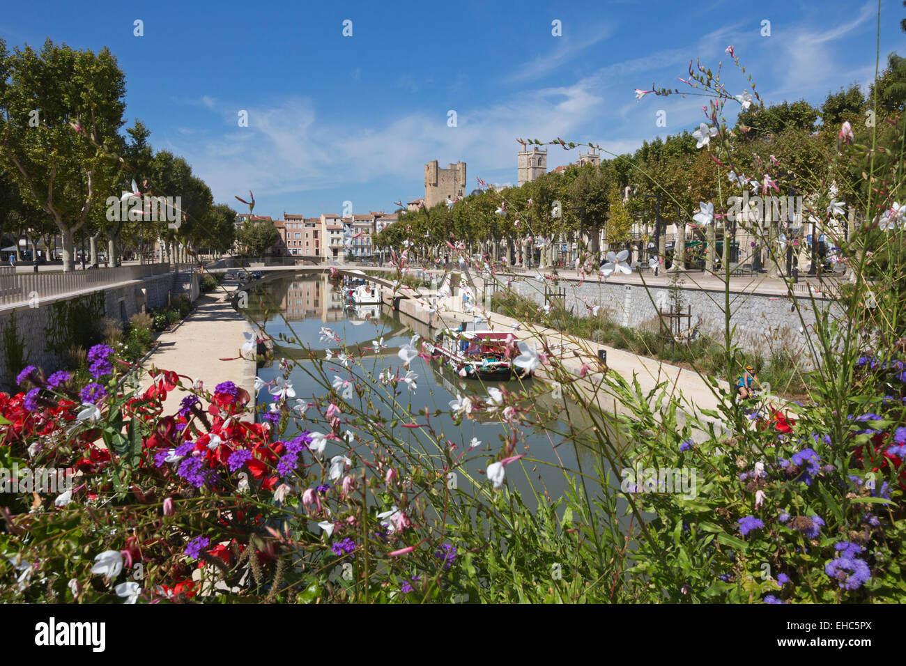 Il Canal du Midi a Narbonne, Aude nella Linguadoca Rossiglione Francia visto attraverso i fiori decorare un bridge crossing Foto Stock