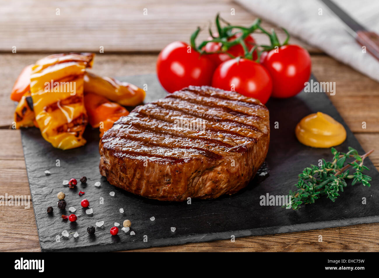 Grigliate di carne di manzo con verdure su una superficie in legno Foto Stock