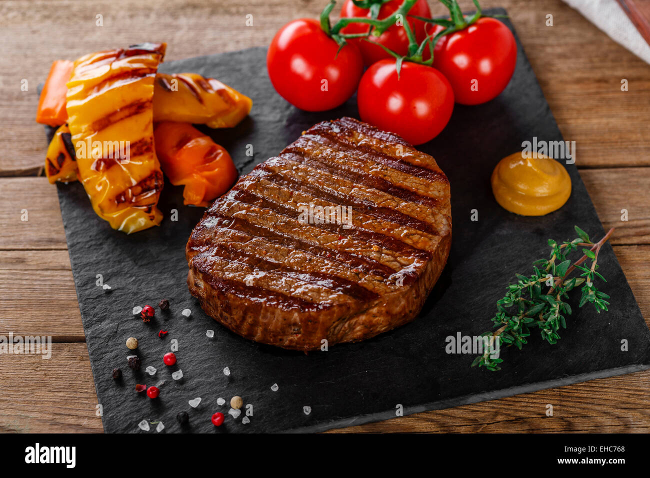 Grigliate di carne di manzo con verdure su una superficie in legno Foto Stock