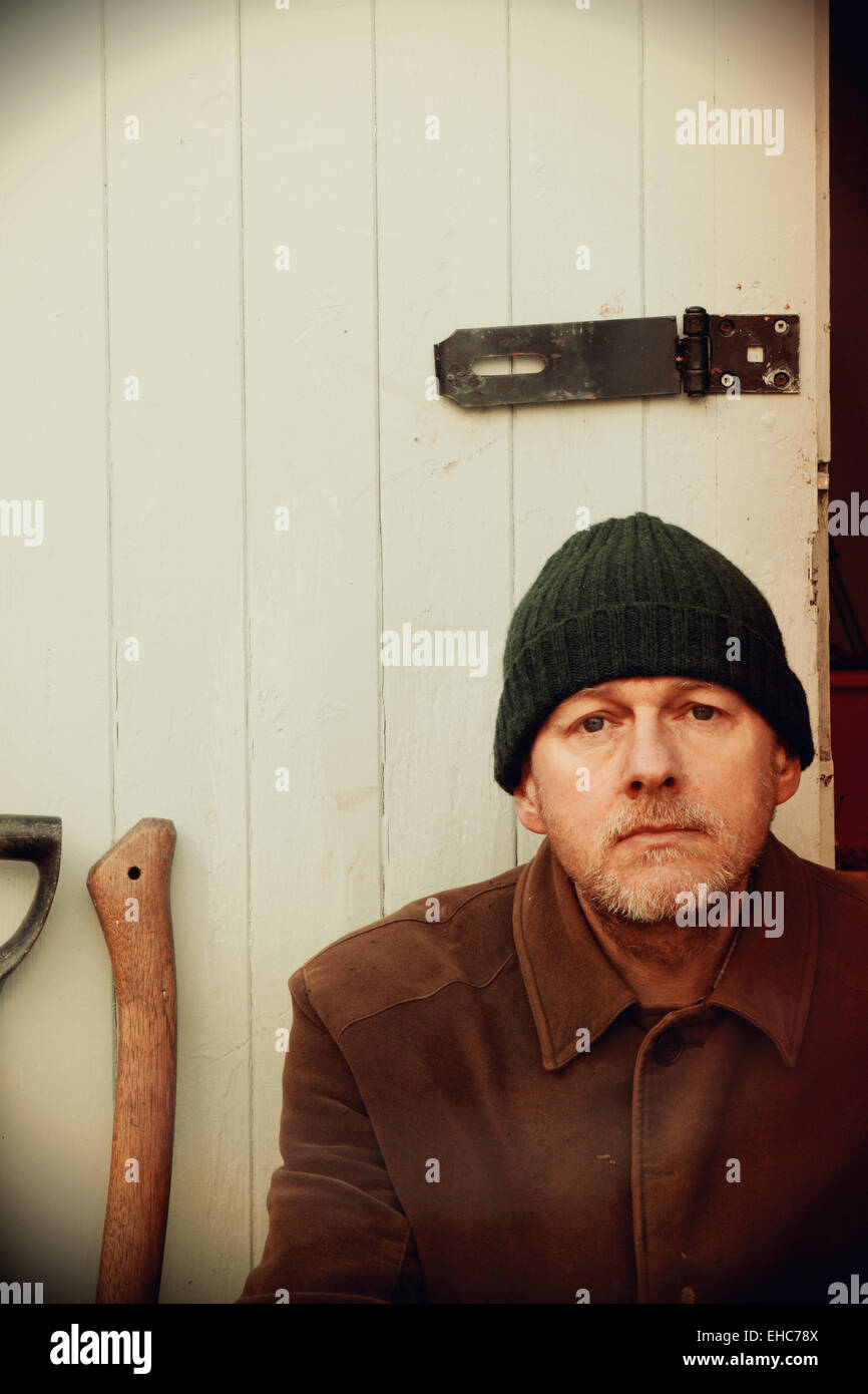 Uomo di età 50 con il wolly hat e strumenti di capannone foto con retro vintage trasformazione Foto Stock