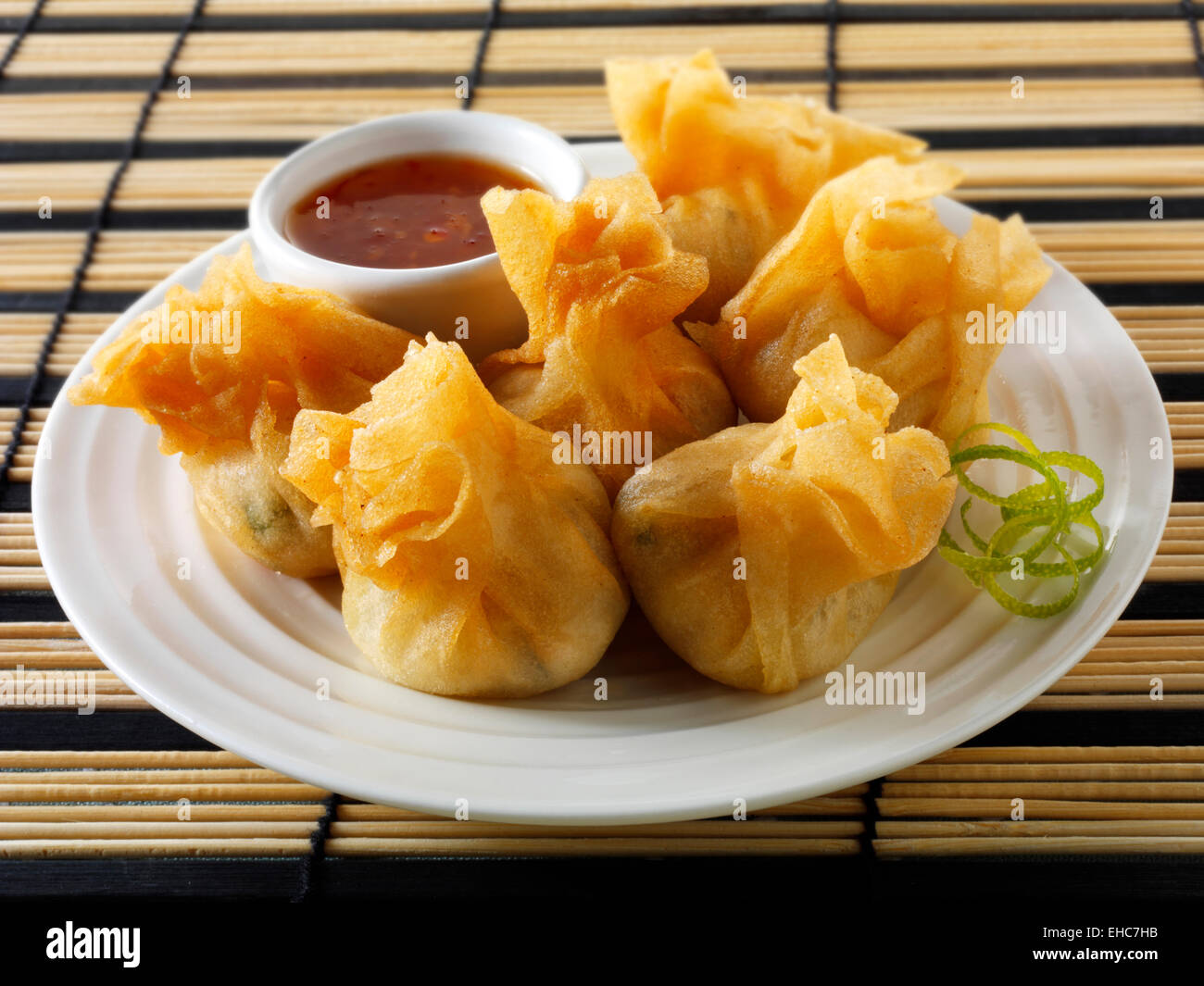 Dim sum cinese tradizionale con salsa di peperoncino, che serve il suggerimento su un piatto Foto Stock