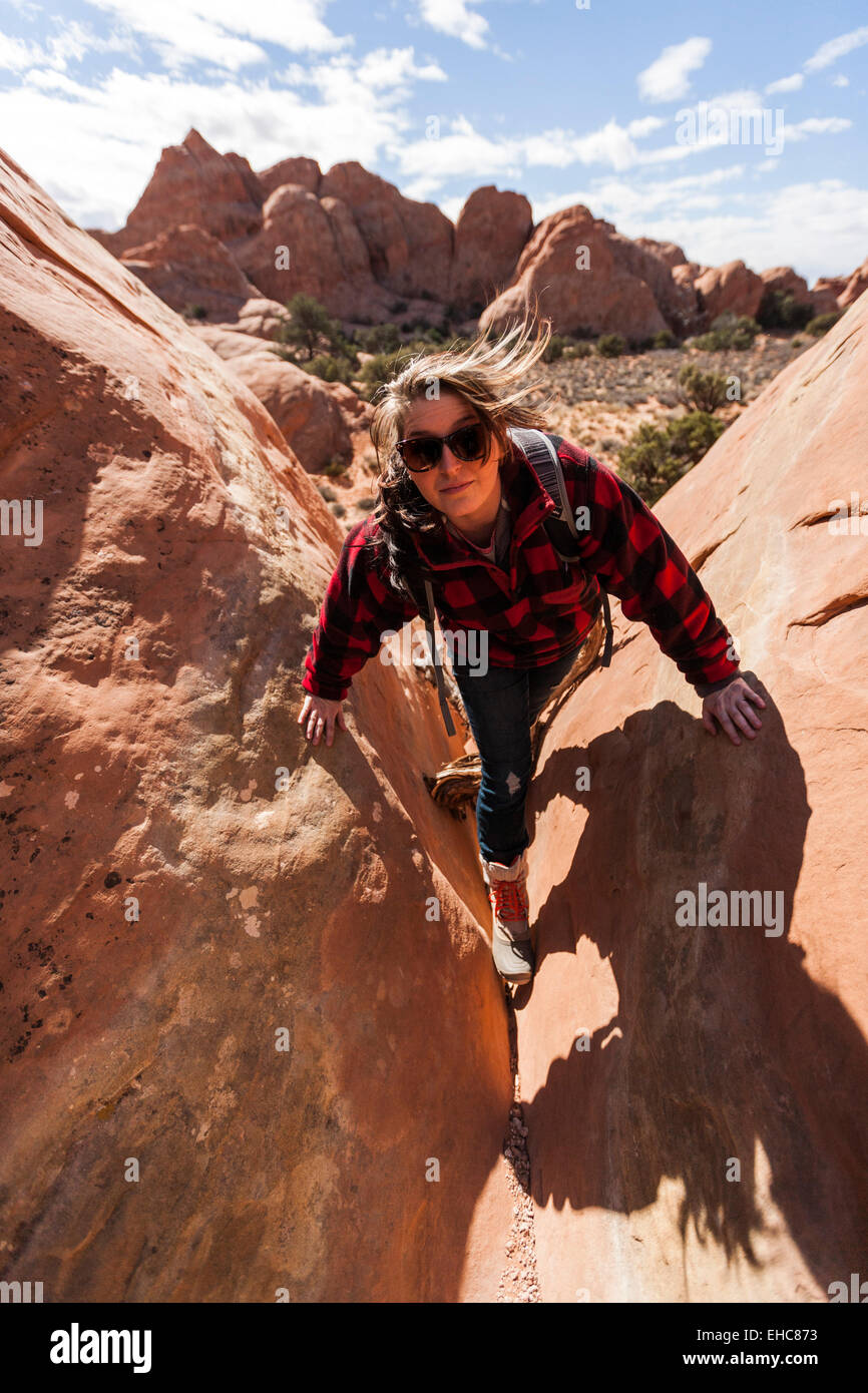 Ampia piena ritratto di una giovane donna escursionismo Red Rocks in dessert al Parco Nazionale di Arches Moab Utah Foto Stock