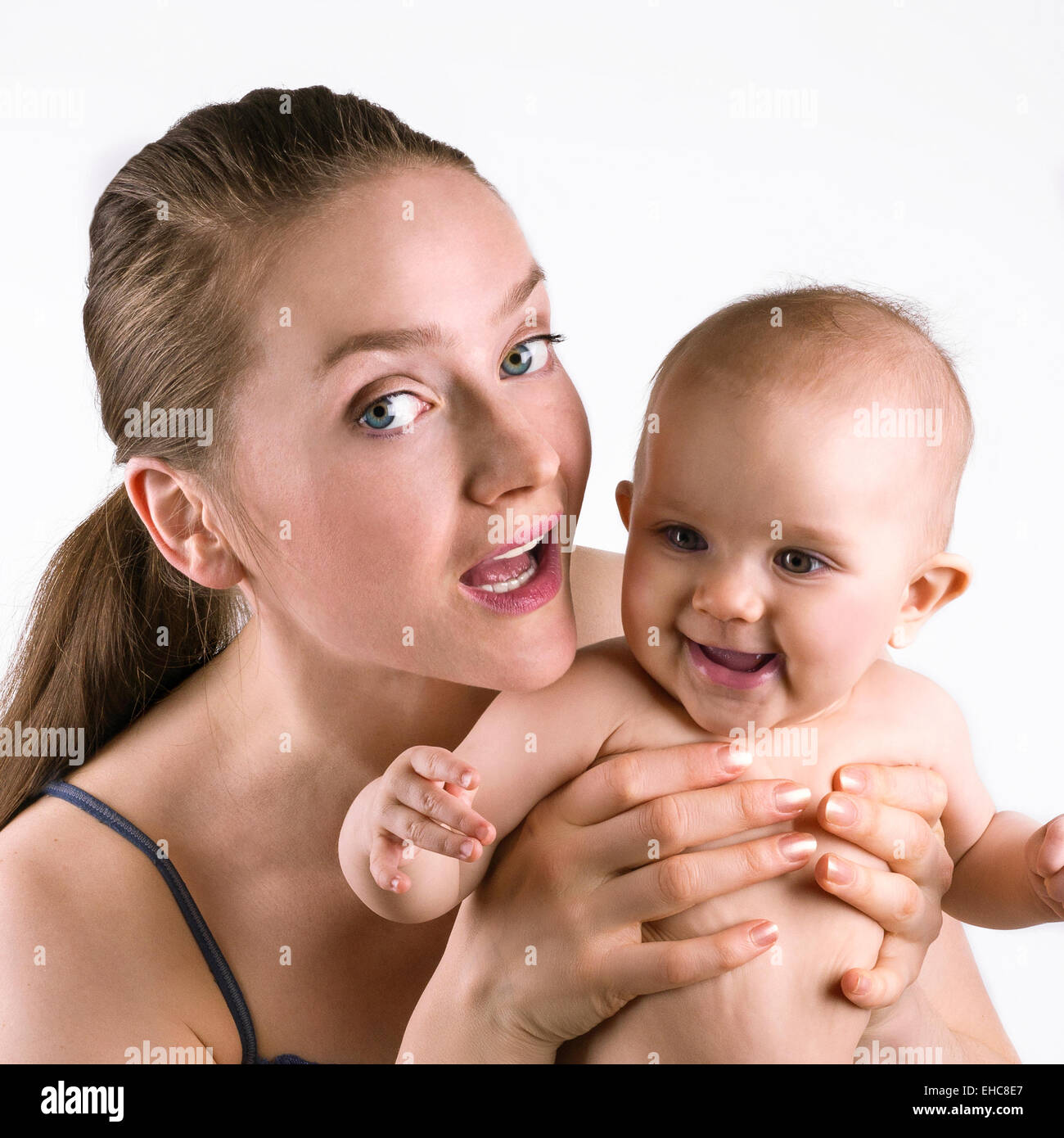 Signora giovane azienda il suo bambino e sorridente su sfondo bianco Foto Stock