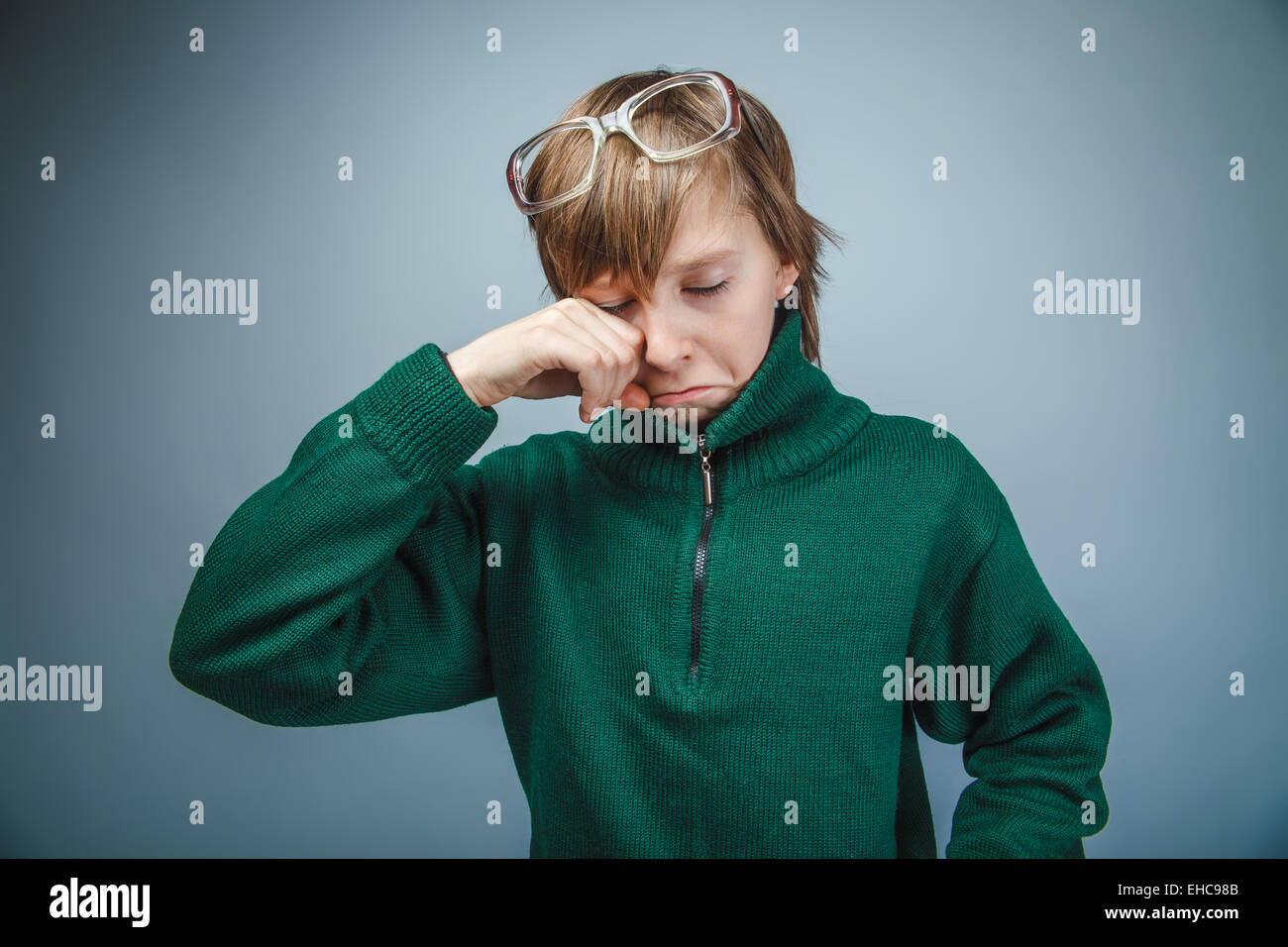 Ragazzo adolescente marrone capelli aspetto europeo in maglione verde wit Foto Stock