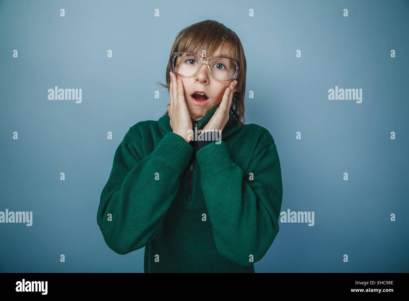 Ragazzo adolescente marrone capelli aspetto europeo in maglione verde ret Foto Stock