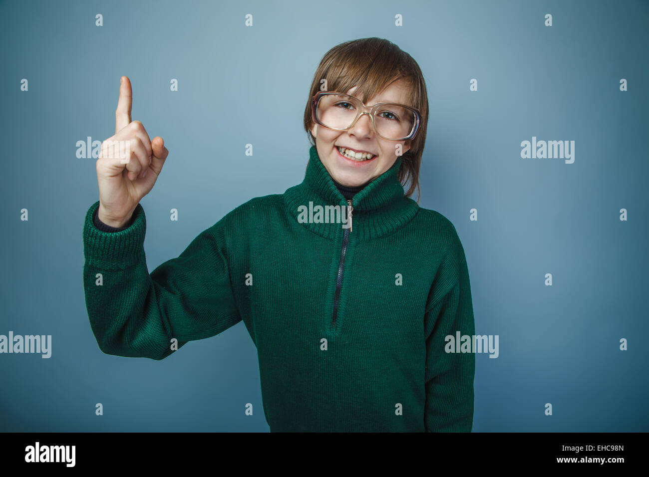 Ragazzo adolescente marrone capelli aspetto europeo in maglione verde wit Foto Stock