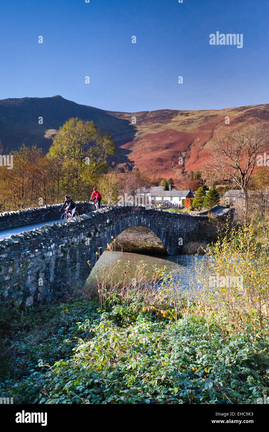 Ciclista attraversando il ponte di Grange, Grange di Borrowdale, Parco Nazionale del Distretto dei Laghi, Cumbria, England, Regno Unito Foto Stock