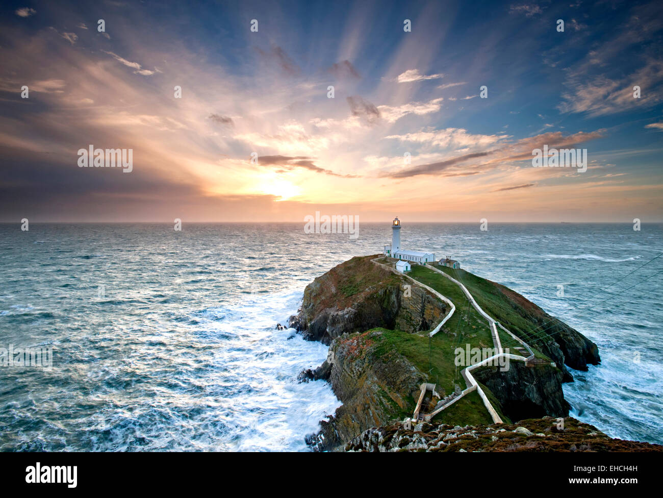 Raggi crepuscolari oltre a sud pila faro al tramonto, Anglesey, Galles del Nord, Regno Unito Foto Stock