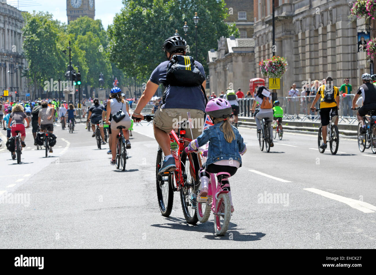 Londra, Inghilterra, Regno Unito. Padre e figlia in bicicletta assieme con una barra Trail-Gator unendo le biciclette. Whitehall Foto Stock