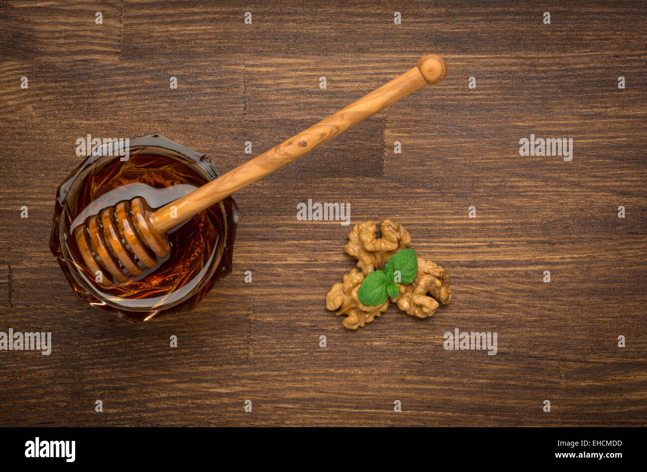Ciotola di miele dadi e menta su un tavolo di legno. Simbolo di uno stile di vita sano e medicina naturale. Aromatico e saporito. Vista dall'alto. Foto Stock