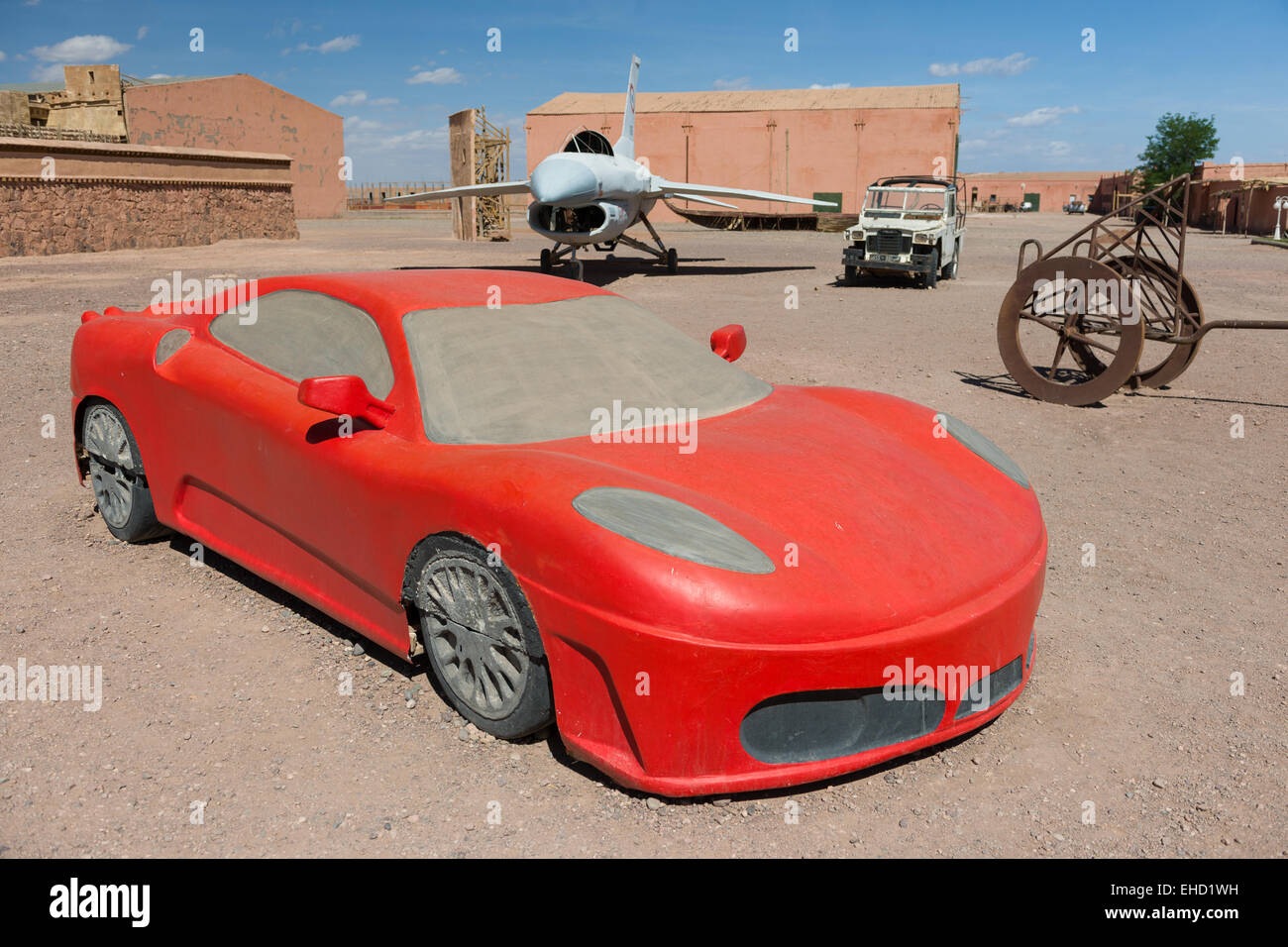Requisito Ferrari in fibra di vetro davanti all'aereo F-16 utilizzato nel film Jewel in the Nile e un carro del film Gladiator, agli Atlas Corporation Film Studios, Ouarzazate, Marocco Foto Stock