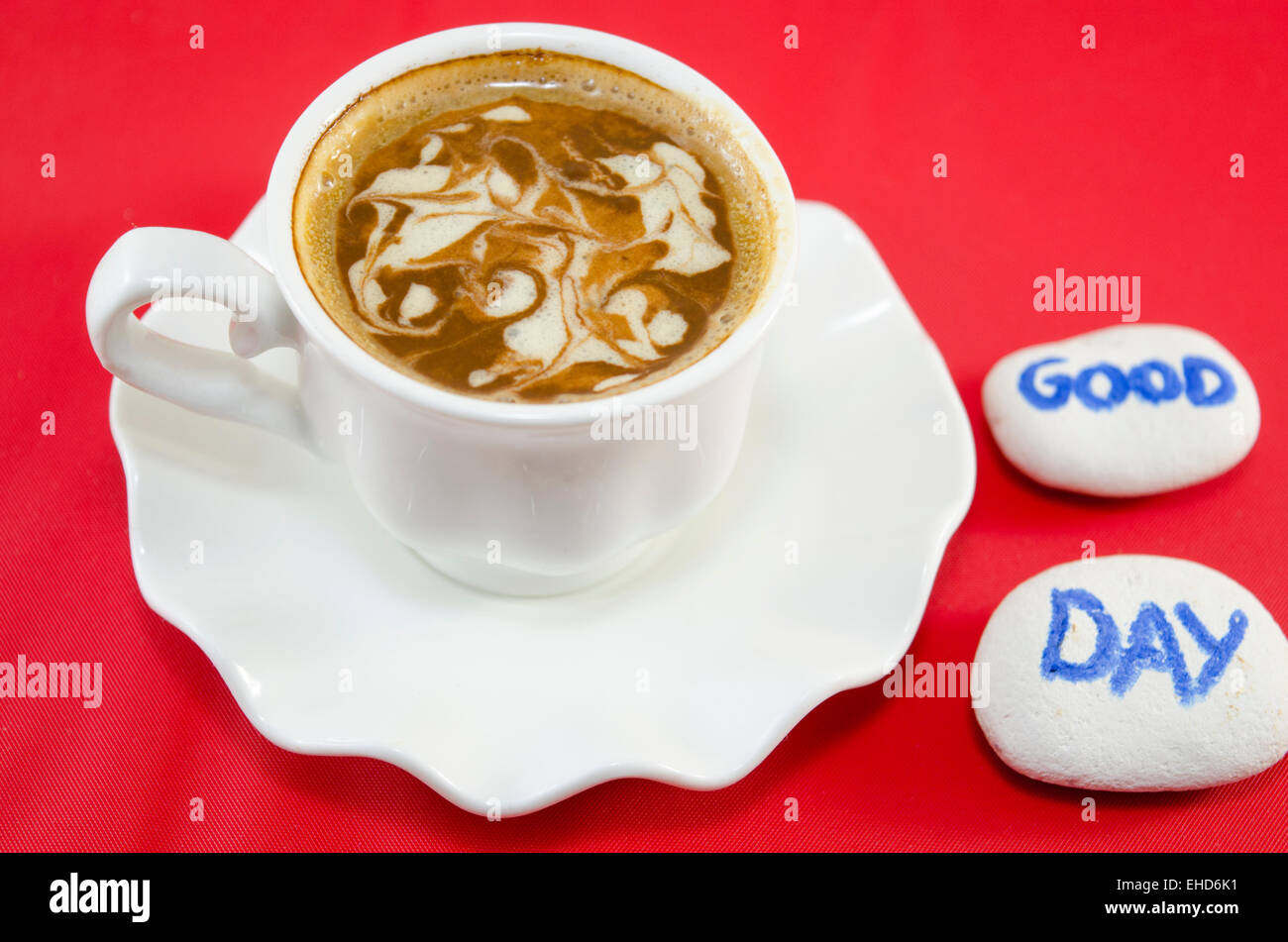 White tazza di caffè con schiuma decorato e rocce dicendo "Buon giorno" Foto Stock