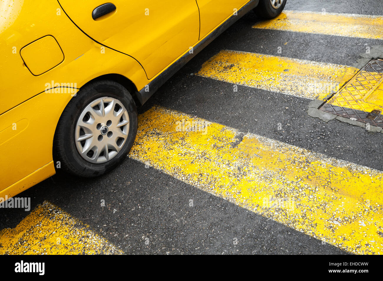 Yellow taxi auto sorge su un attraversamento pedonale con linee come la segnaletica stradale Foto Stock