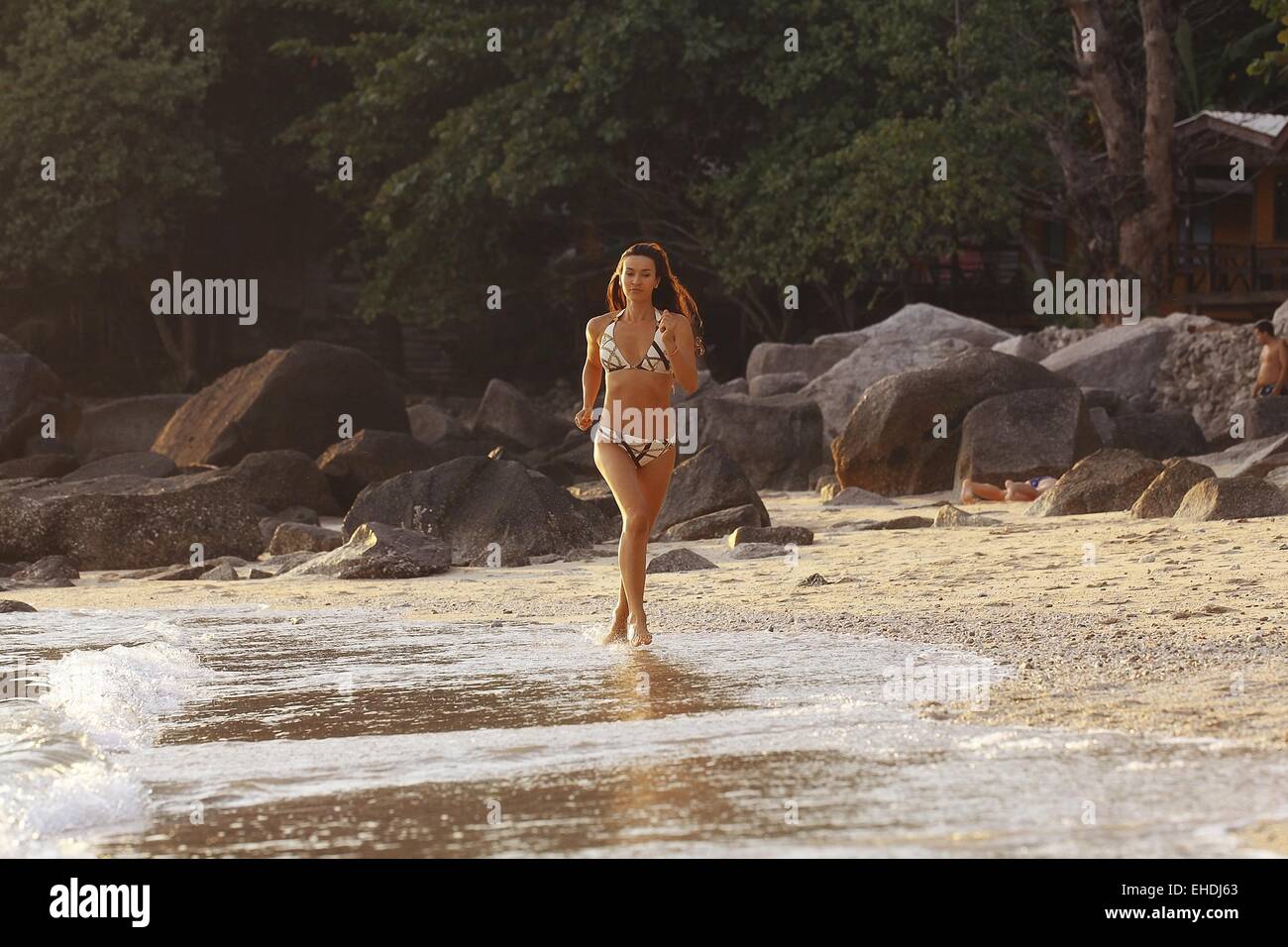 Bella ragazza corre lungo la spiaggia vacanze fitness Foto Stock