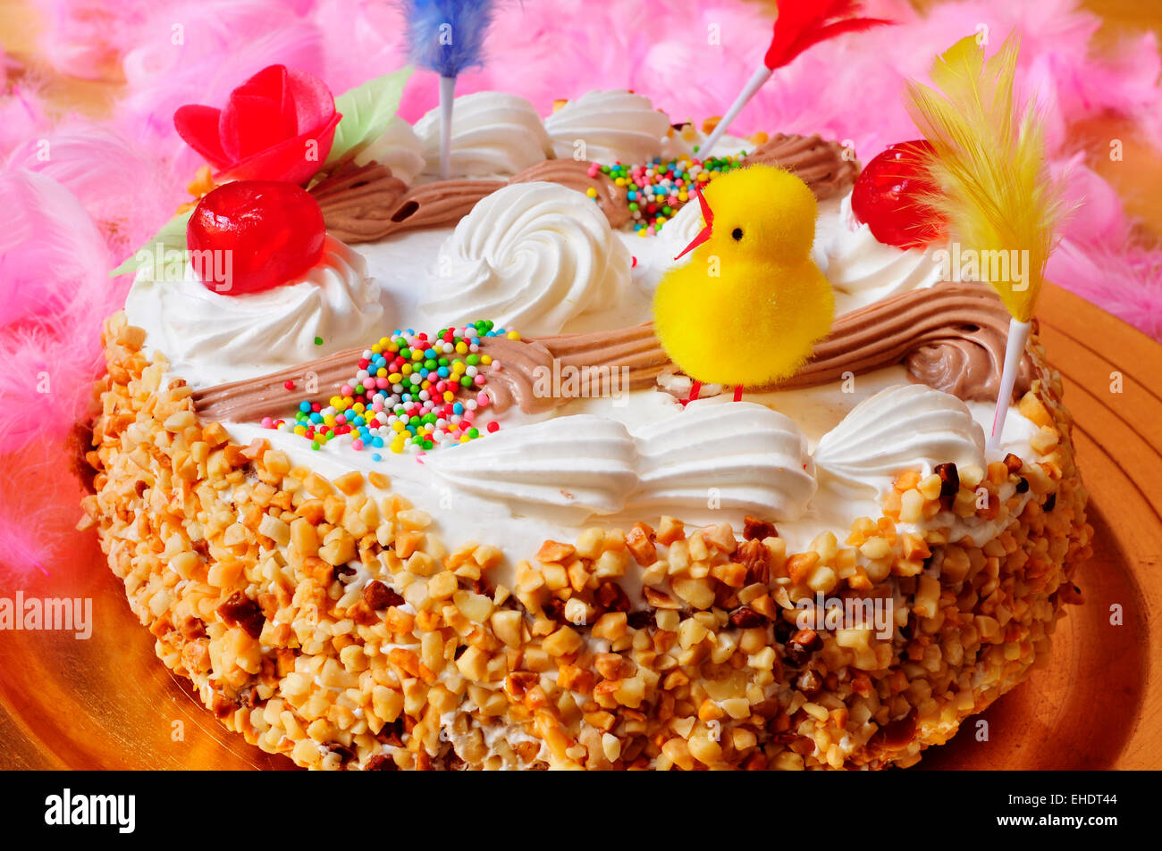 Primo piano di un mona de Pascua, una torta mangiata in Spagna il lunedì di Pasqua, ornata con piume e un pulcino di peluche Foto Stock