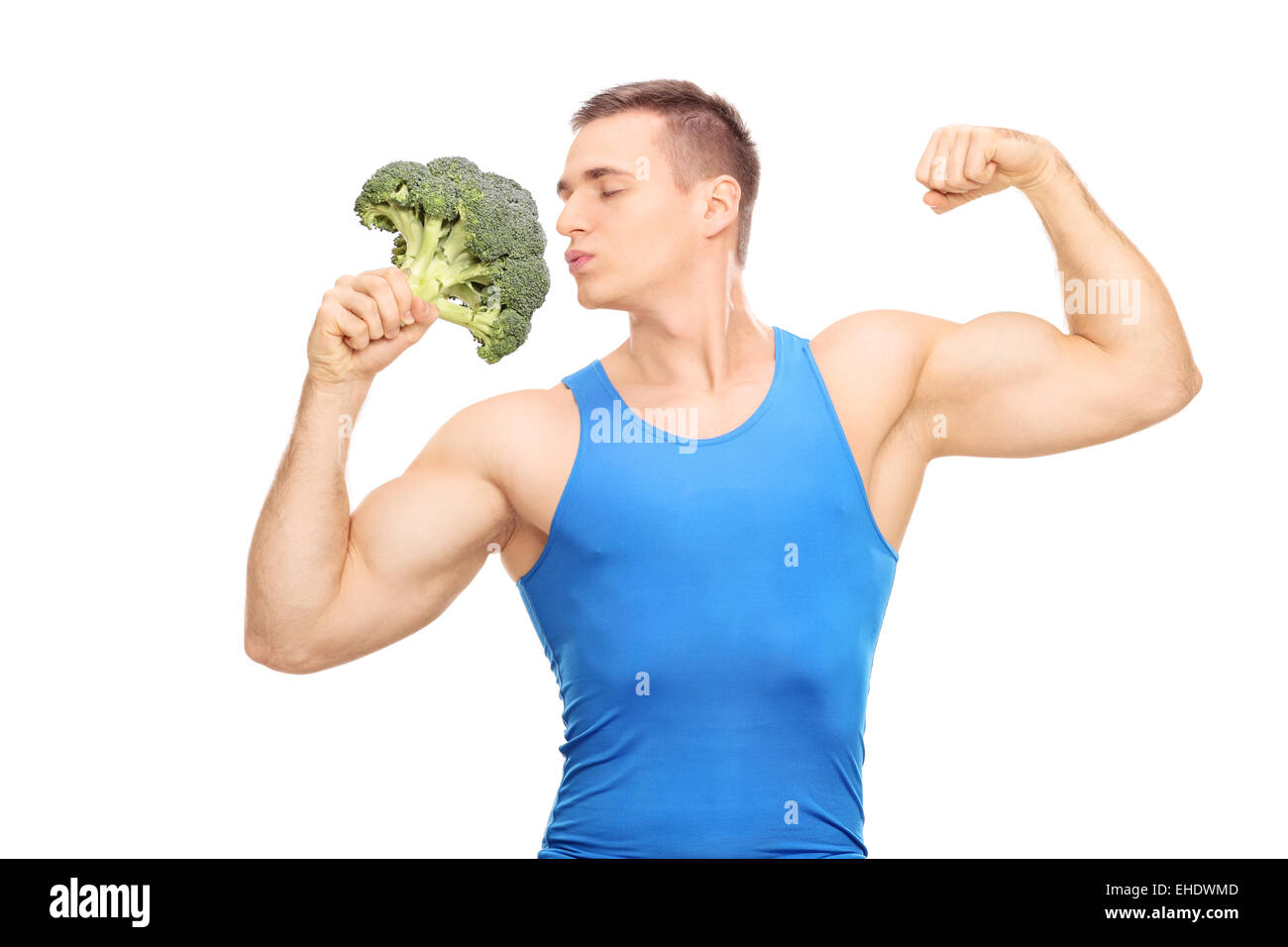 Uomo muscolare baciando un enorme pezzo di broccoli isolati su sfondo bianco Foto Stock