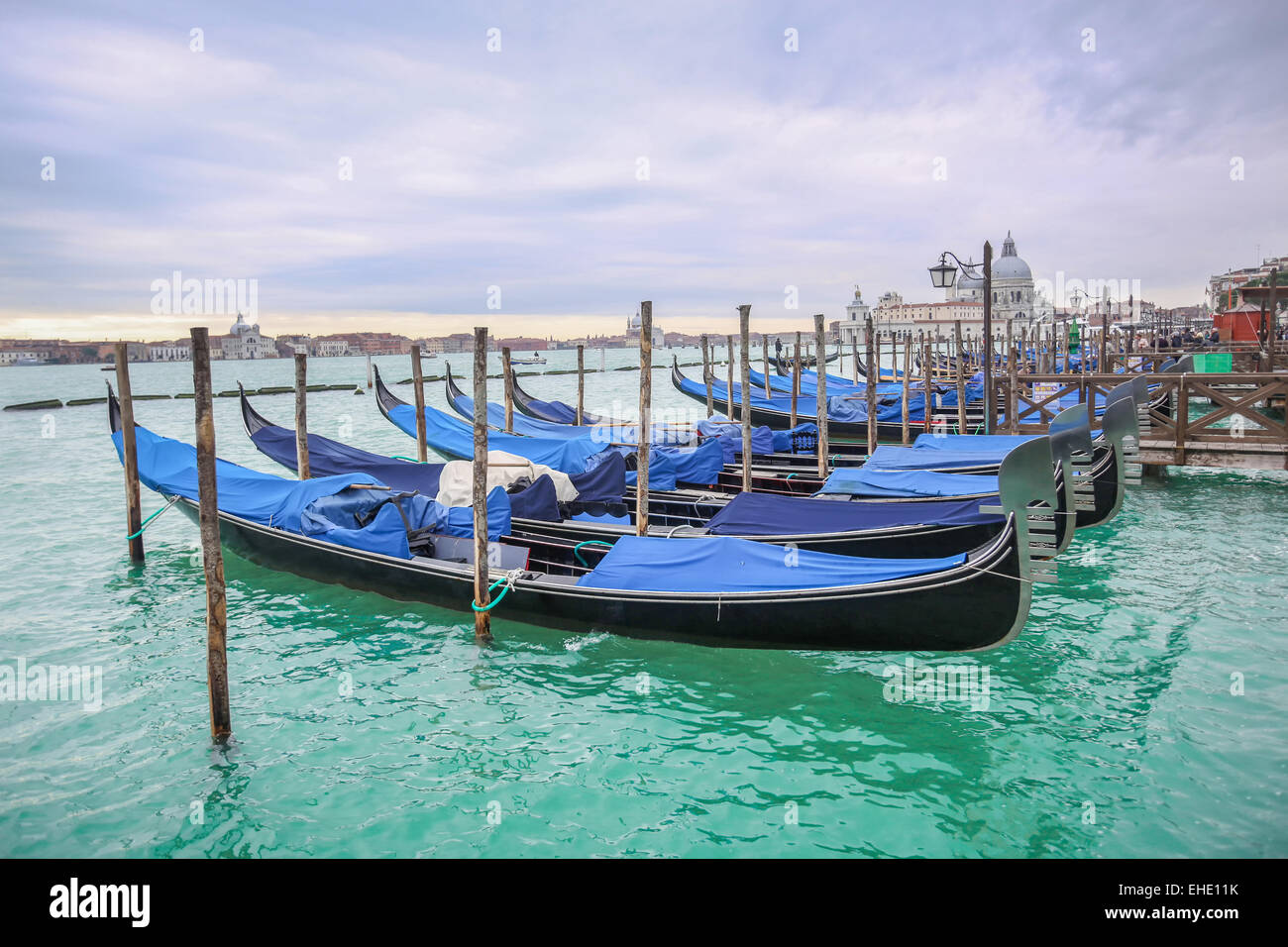 Gondole attraccate in acqua con una vista della chiesa di Santa Maria della Salute, a Venezia, Italia. Foto Stock