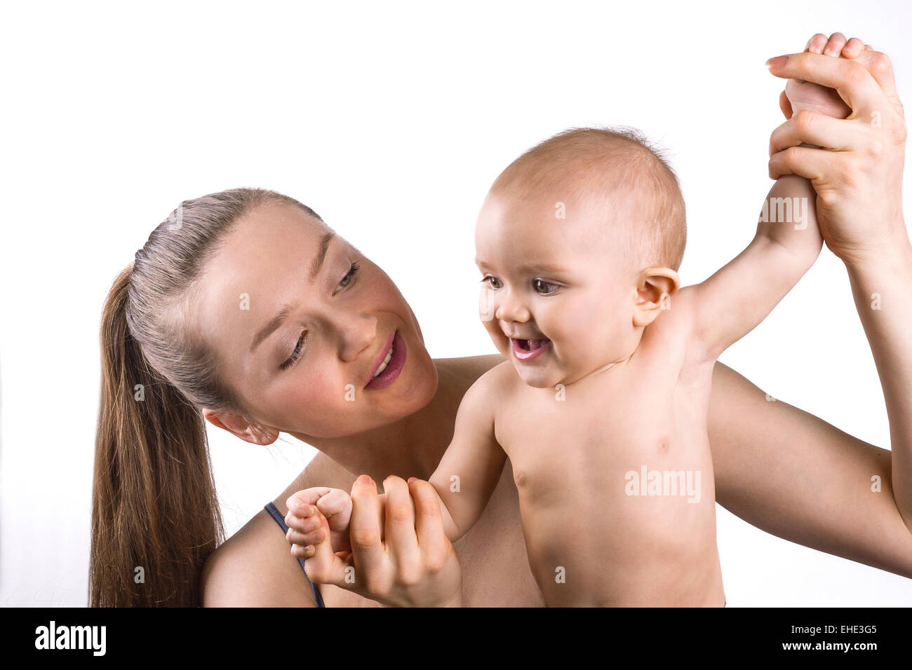 Giovane madre tenendo il suo bambino e sorridente insieme su sfondo bianco. Foto Stock