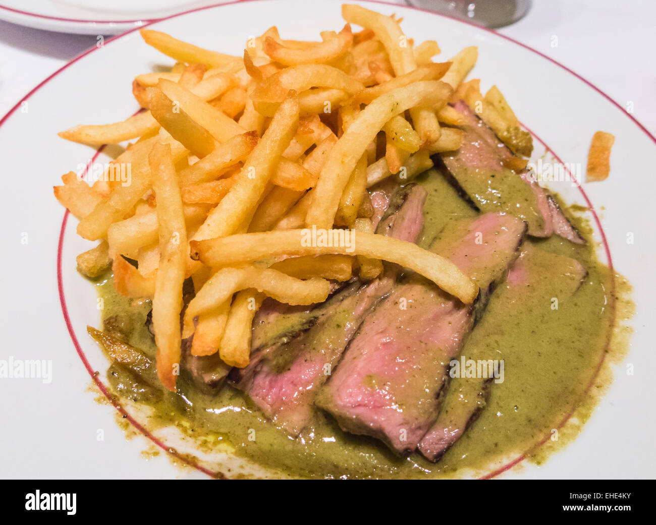 Piastra della deliziosa bistecca cotta mezzo raro) in una salsa al pepe verde e croccante golden francese patatine fritte Foto Stock