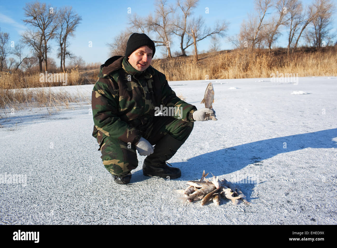 Pescatore sul lago d'inverno Foto Stock