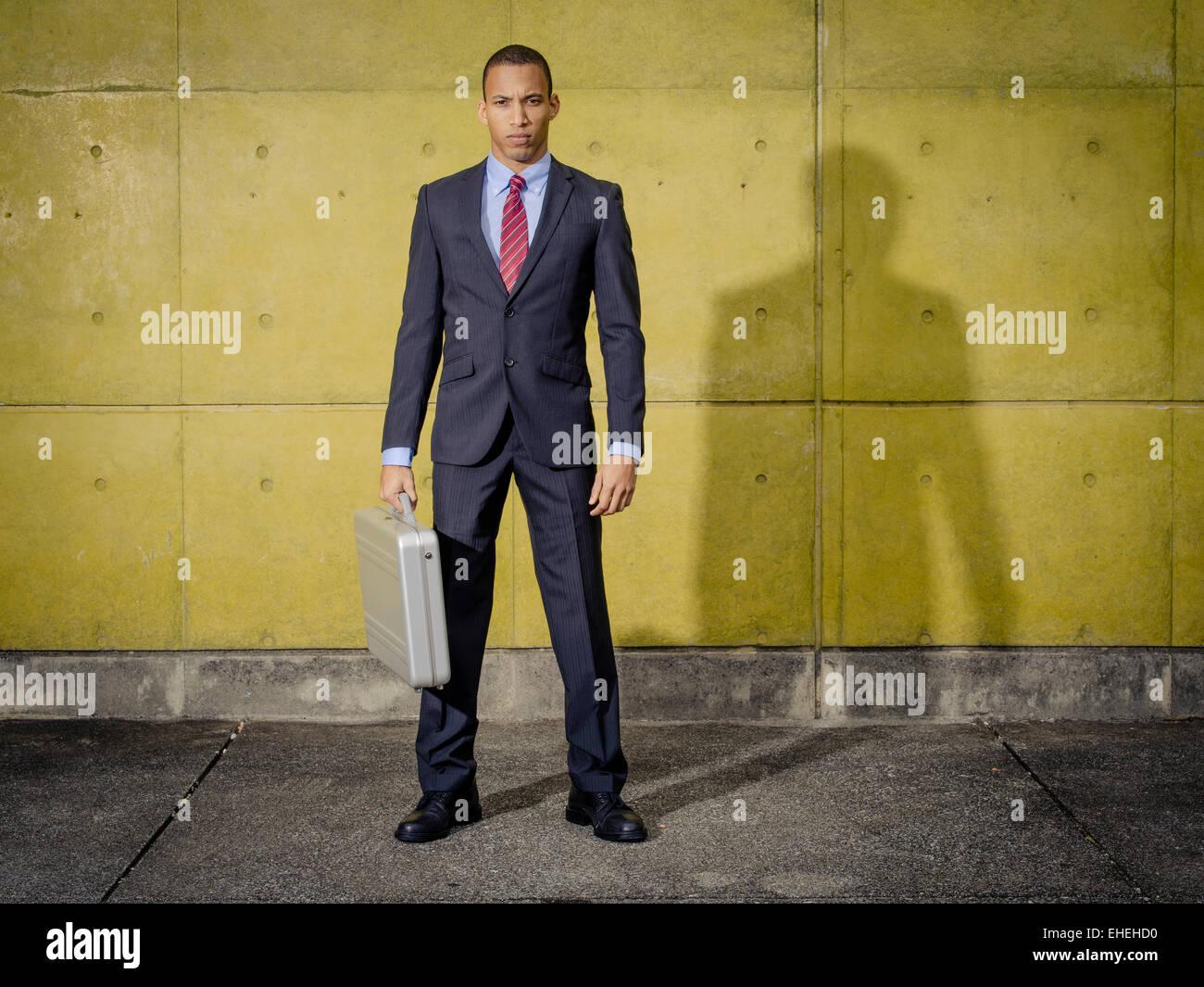 Imprenditore ritratto di indossare tuta e cravatta con Halliburton Zero in alluminio valigetta in alluminio / attache caso Foto Stock